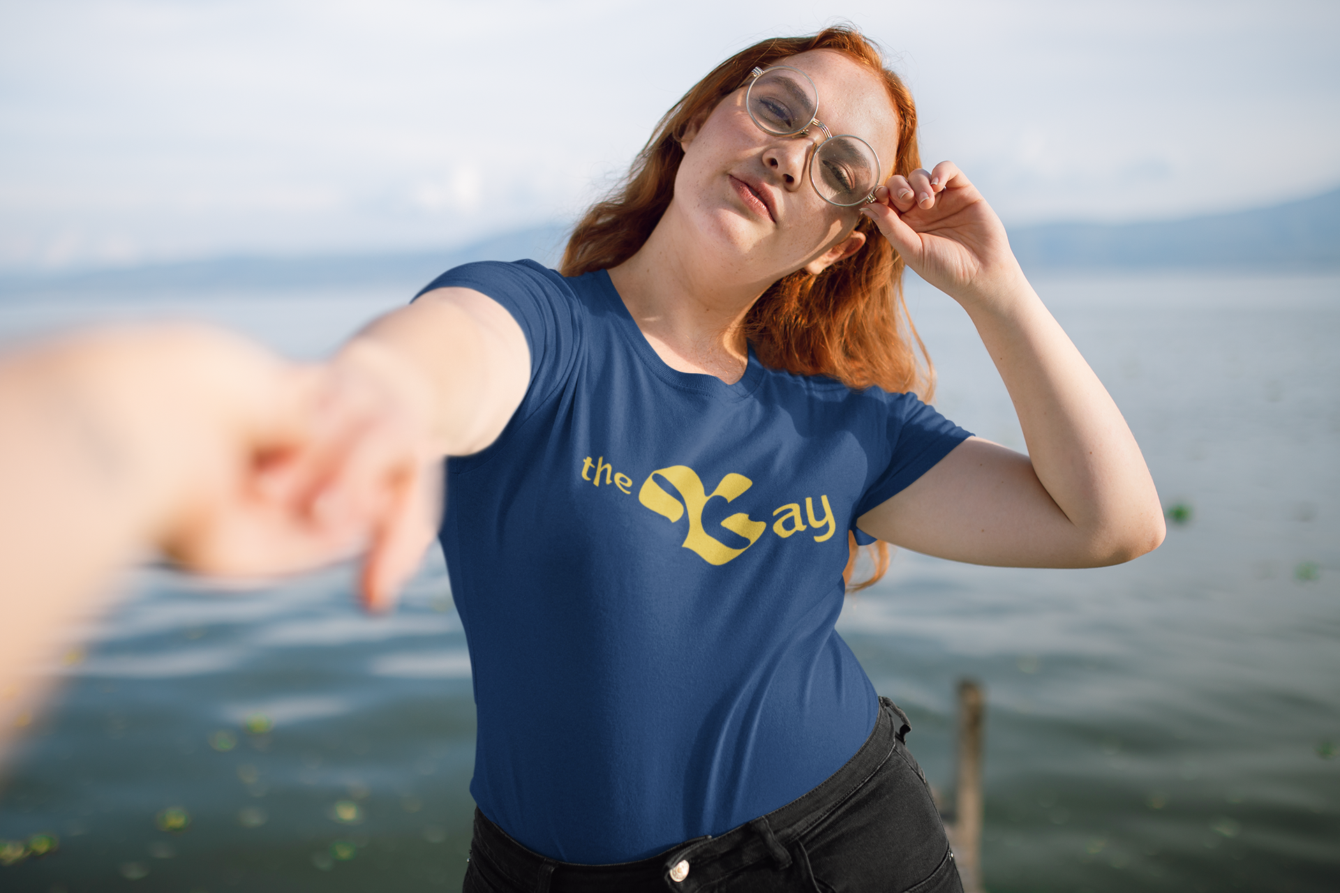 women in front of a lake wearing navy blue tshirt with "the gay" written on it