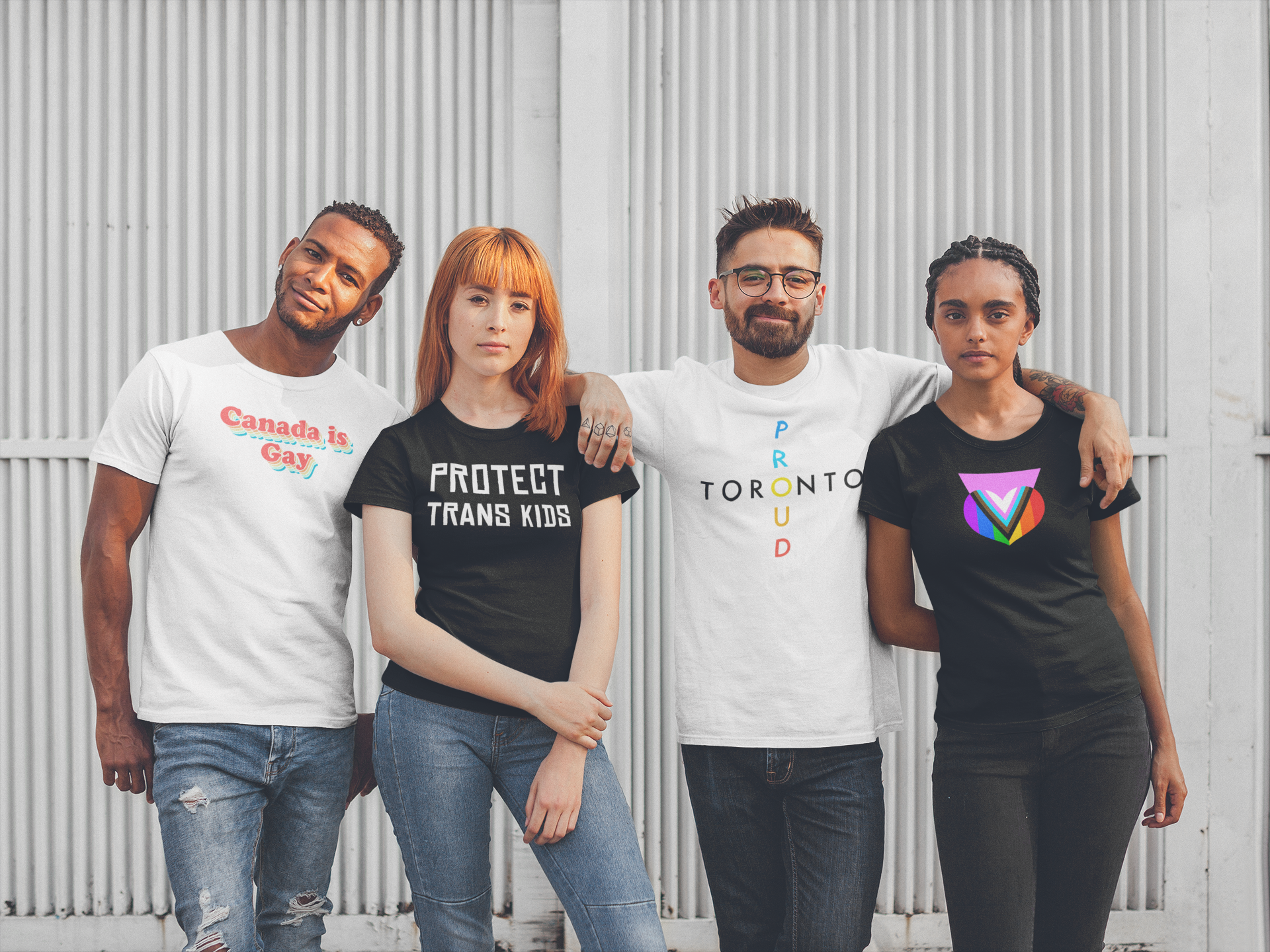 a group of four friends pose with Queer Geekery t-shirts on. On the left is a white tee that says "Canada is gay" in retro lettering; to the right of that, a black tshirt with "protect trans kids" in white text; to the right of that a white tshirt with "Toronto Proud" in colourful lettering; then a black shirt with the pink progress pride heart design. 